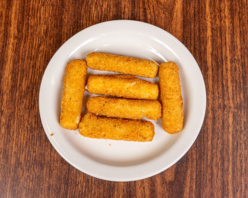 Six golden-brown mozzarella sticks arranged on a white plate on a wooden table.